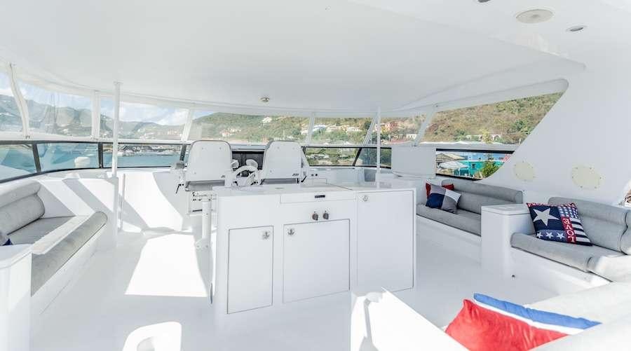 a white room with a white couch and a white table and chairs aboard PRIME TIME Yacht for Charter