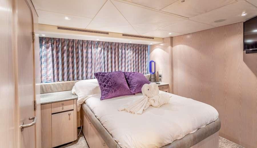 a bedroom with a bed and a window aboard PRIME TIME Yacht for Charter