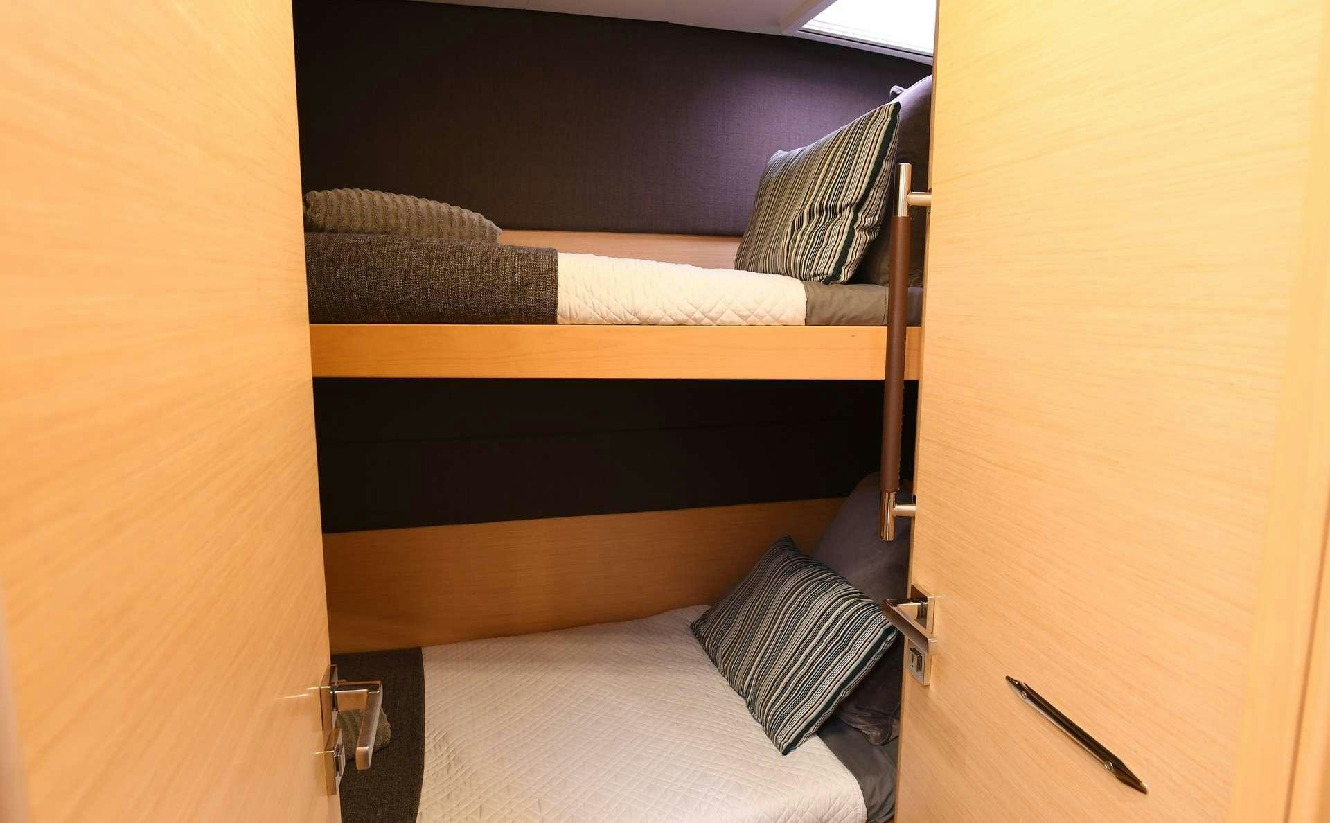 a bed with a wooden headboard aboard VIRAMAR Yacht for Charter