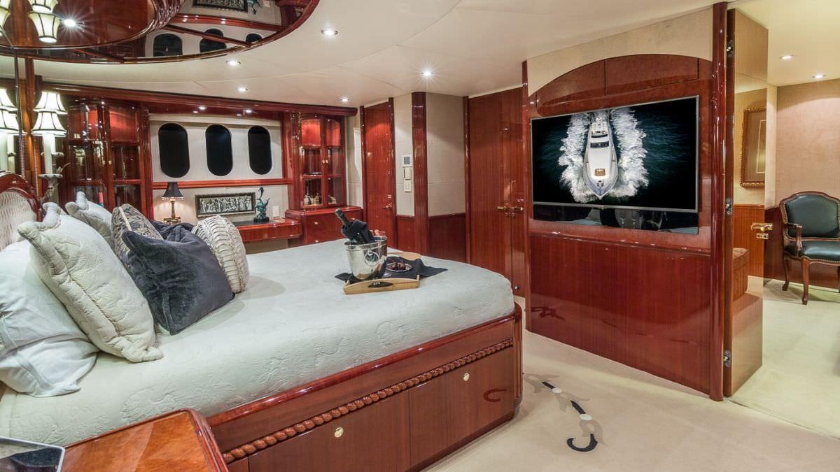 a room with a bed and a red cabinet aboard CEDAR ISLAND Yacht for Charter