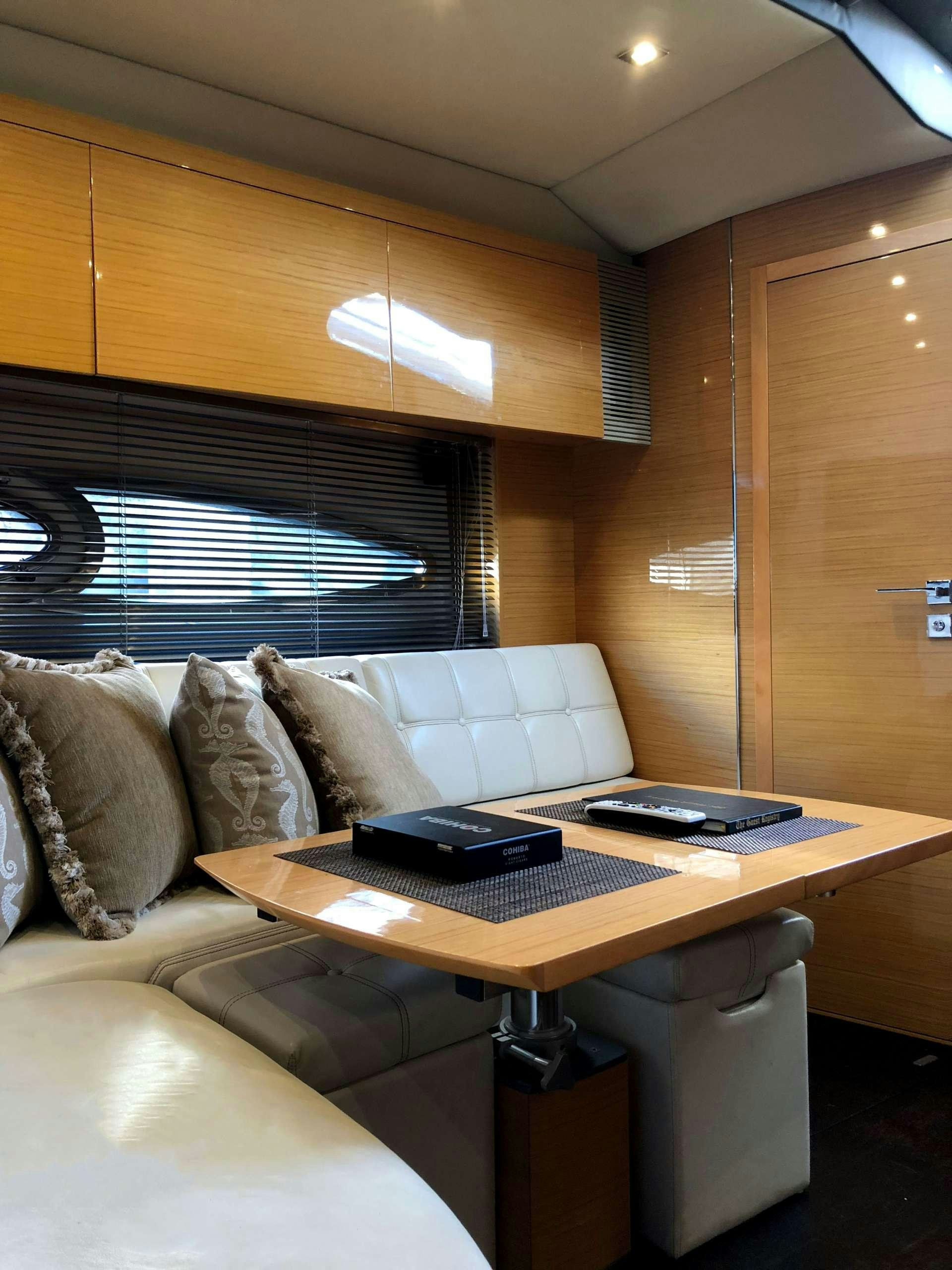 a living room with a couch and a laptop on a table aboard SOL Yacht for Charter