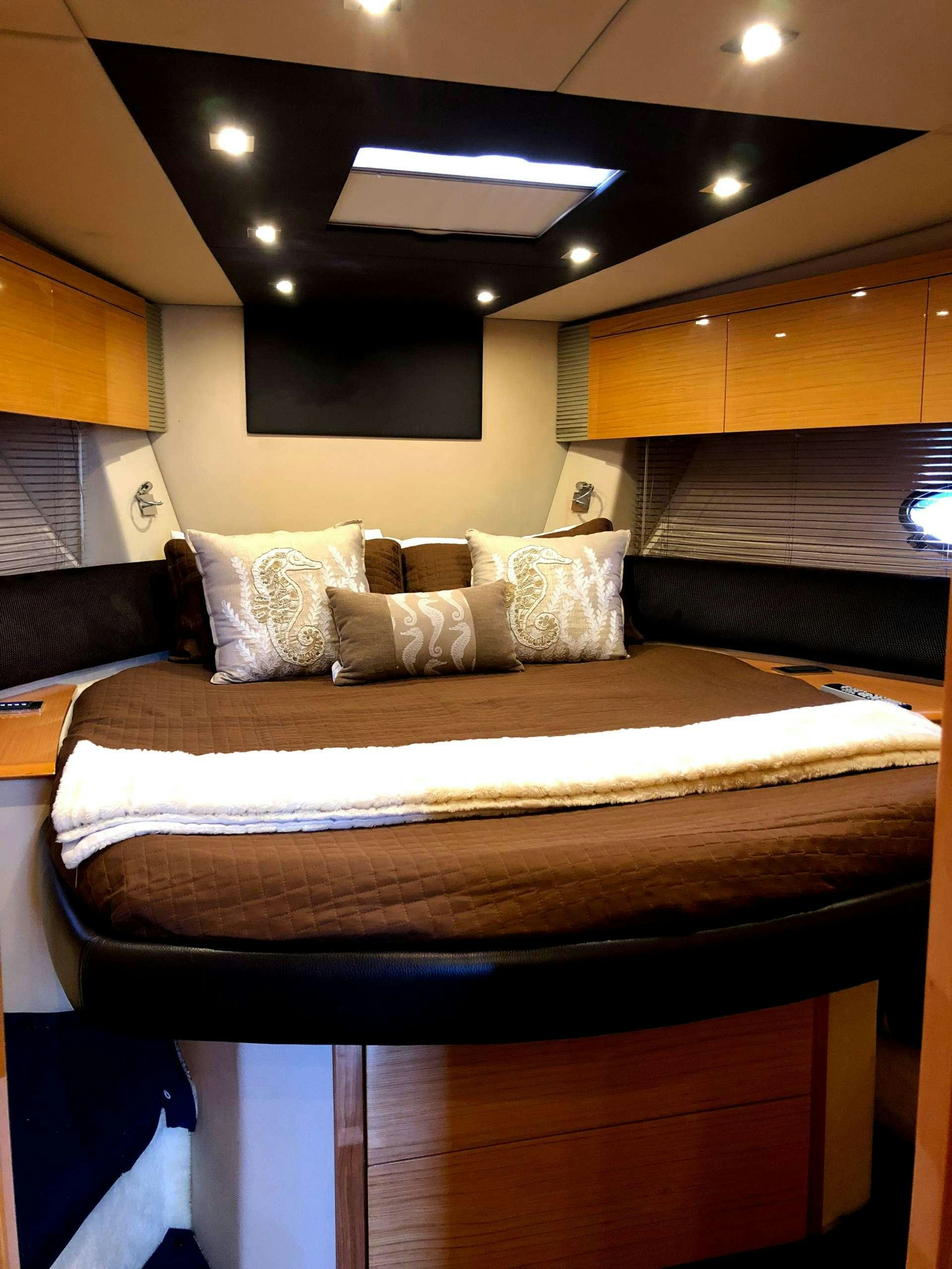 a bed with a white comforter aboard SOL Yacht for Charter