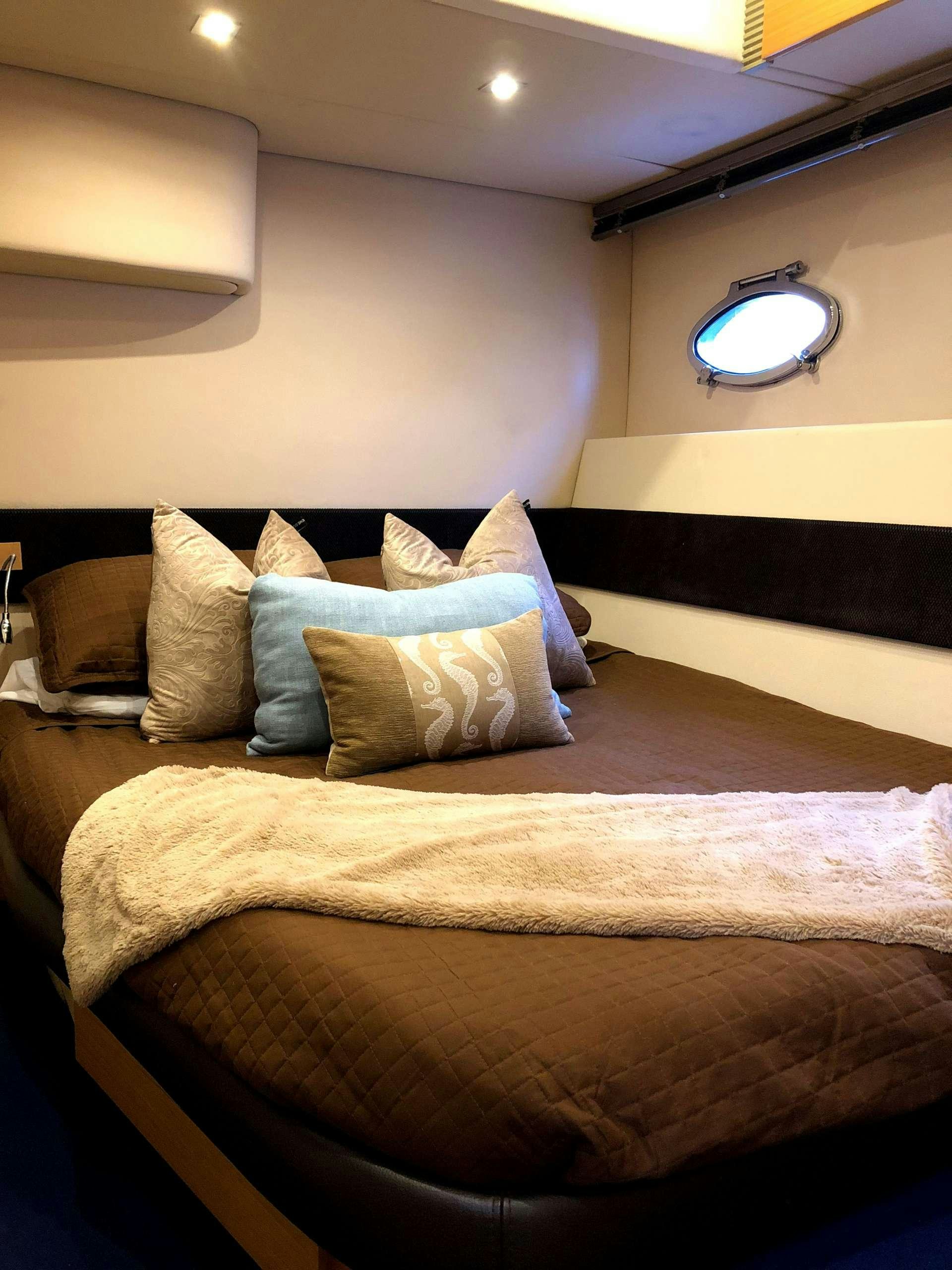 a bed with pillows aboard SOL Yacht for Charter