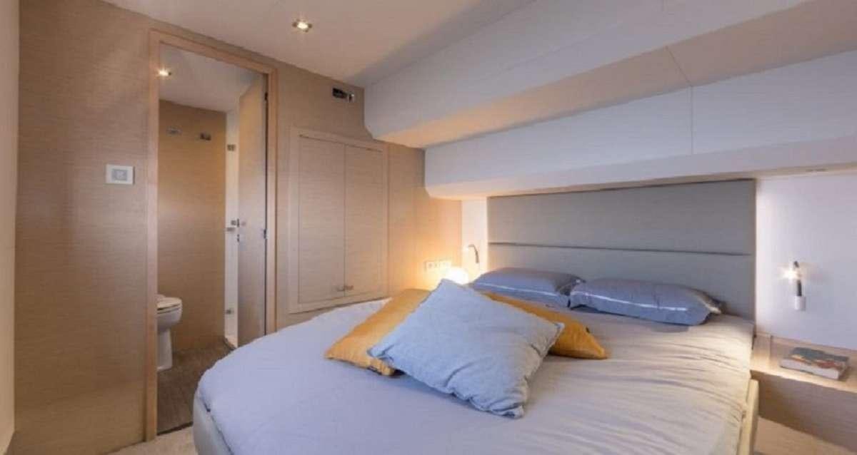 a bed with a white bed spread aboard Hondo Yacht for Charter