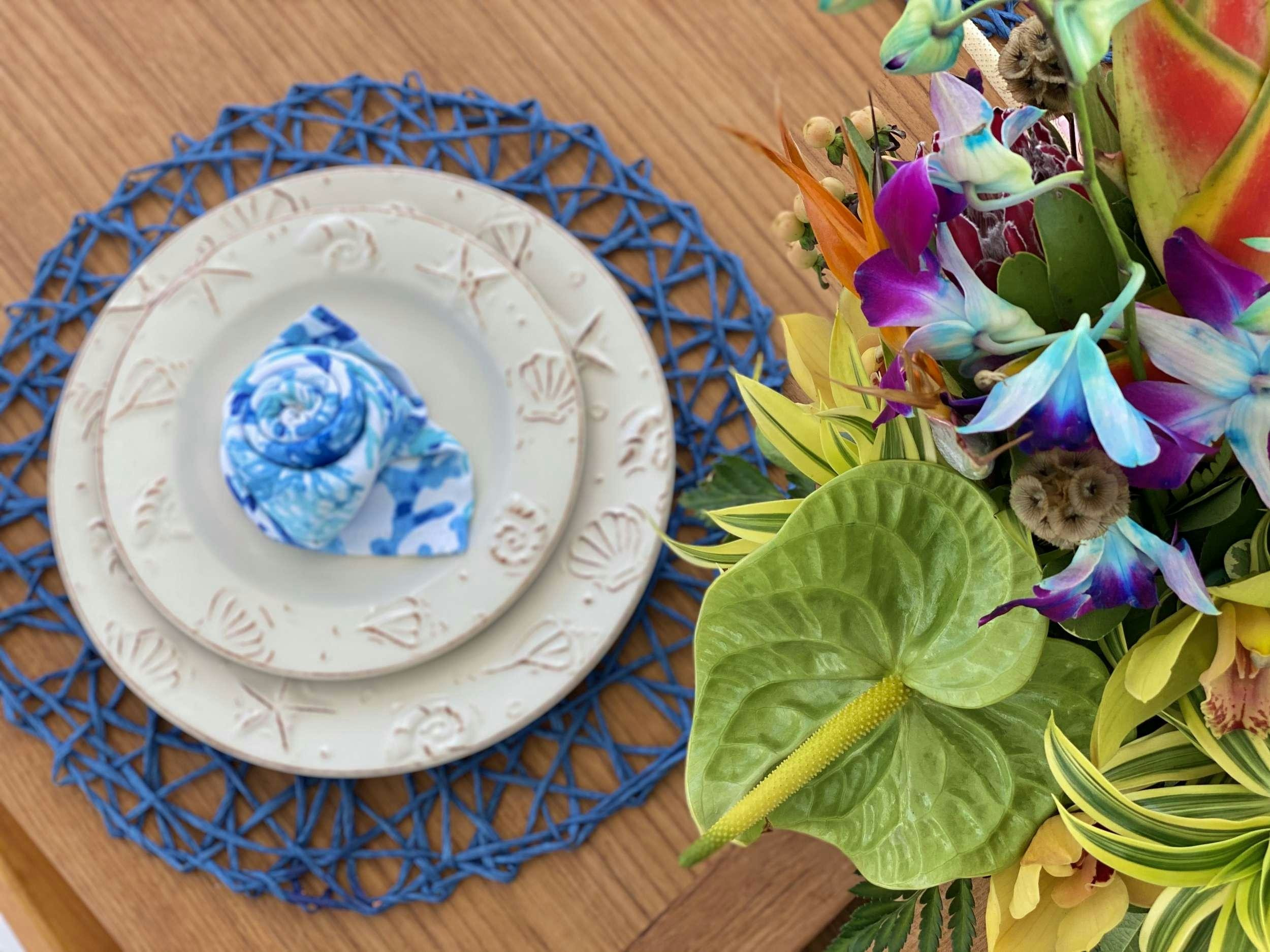 a plate with a blue flower and a bird on it aboard NAUTI CAT Yacht for Charter