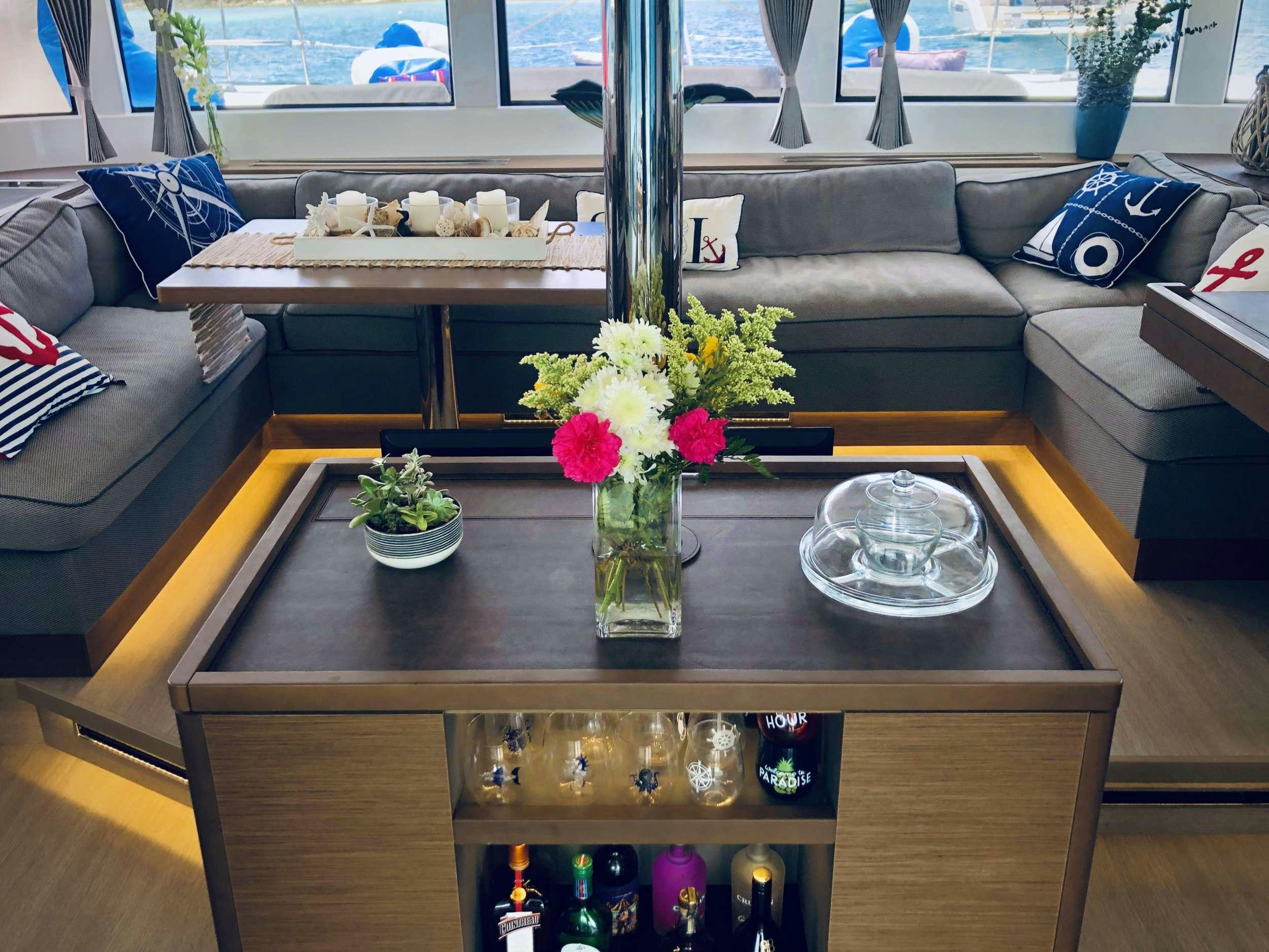 a vase of flowers on a coffee table aboard NAUTI CAT Yacht for Charter
