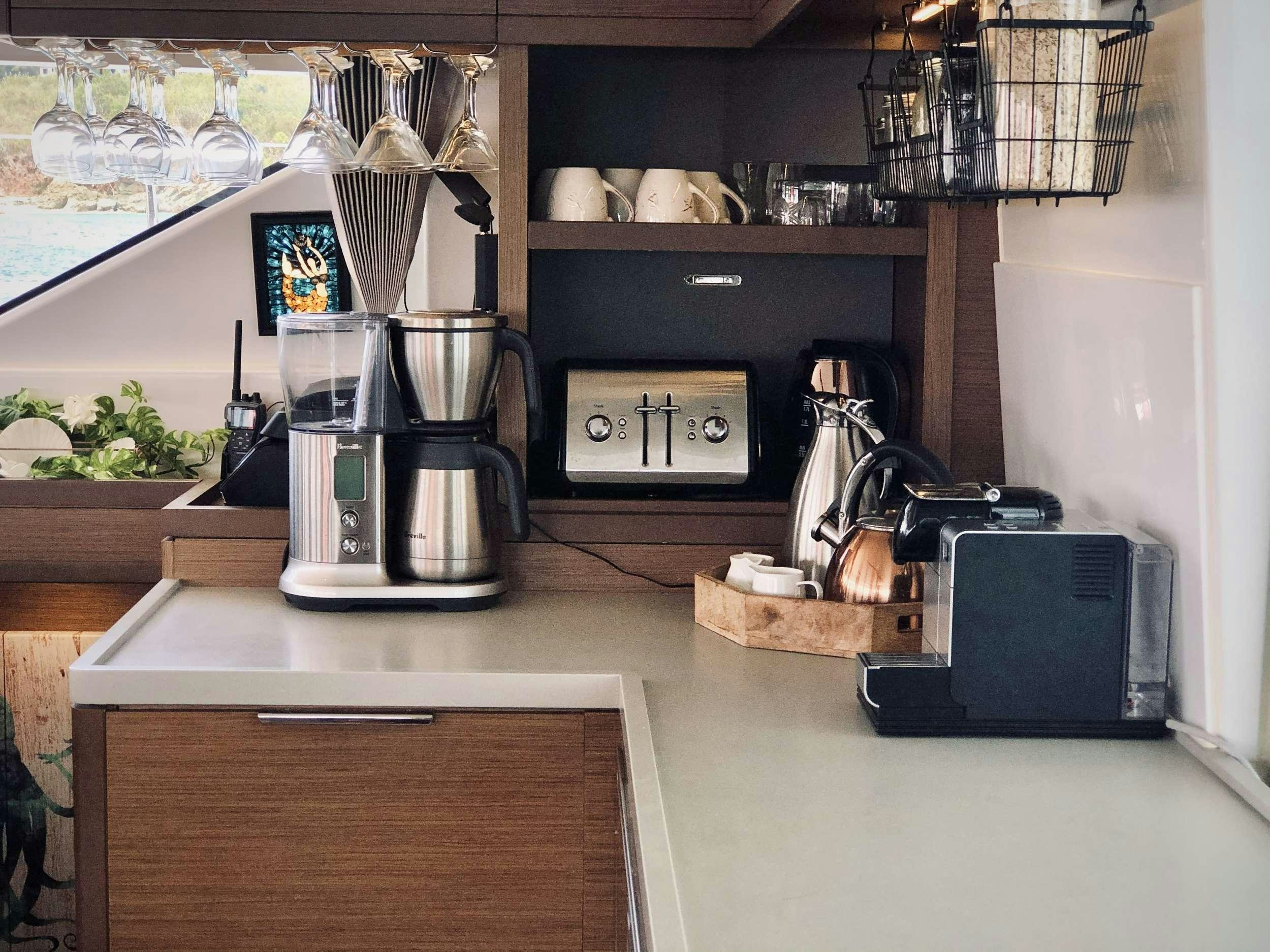 a kitchen with a coffee maker aboard NAUTI CAT Yacht for Charter