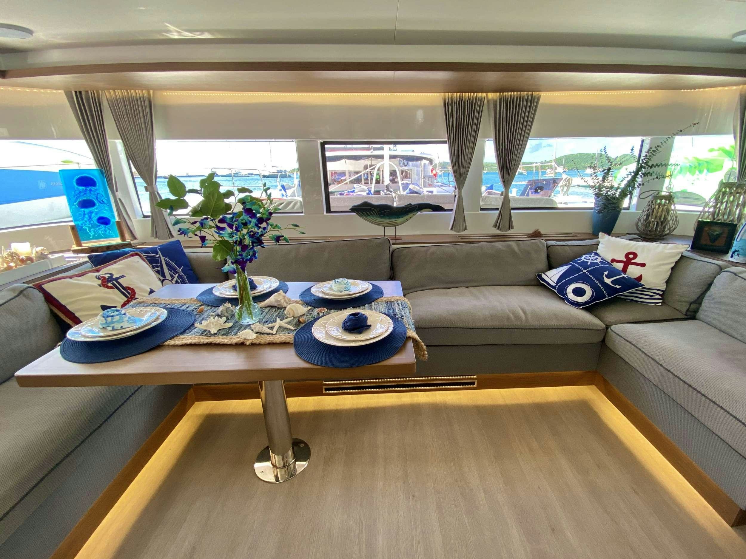 a living room with a couch and a table aboard NAUTI CAT Yacht for Charter