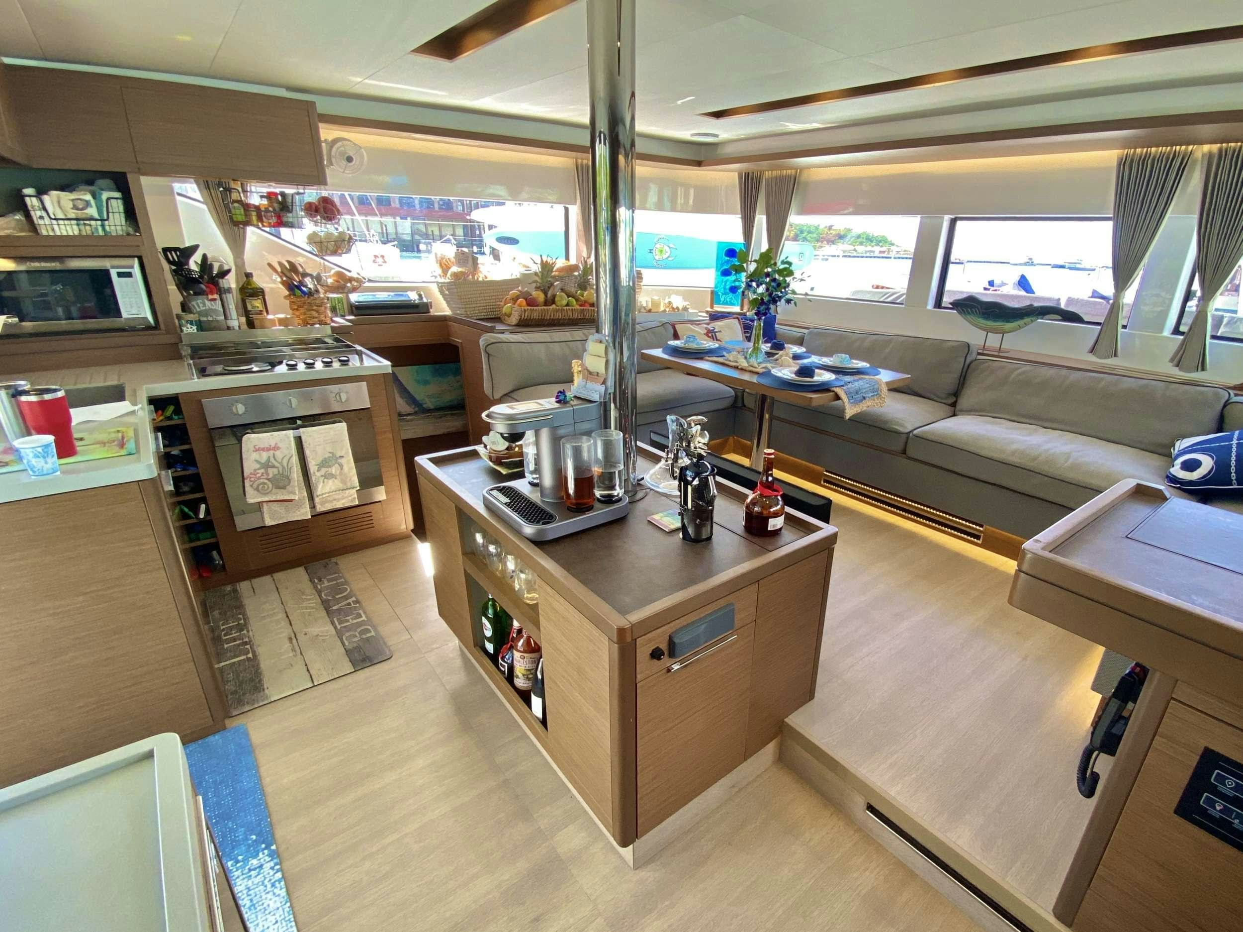 a room with a couch and a table with a coffee table aboard NAUTI CAT Yacht for Charter