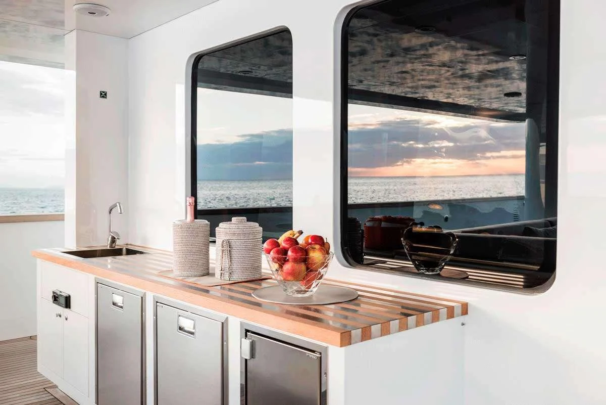 a kitchen with a large flat screen television and white cabinets aboard GENESIA Yacht for Charter