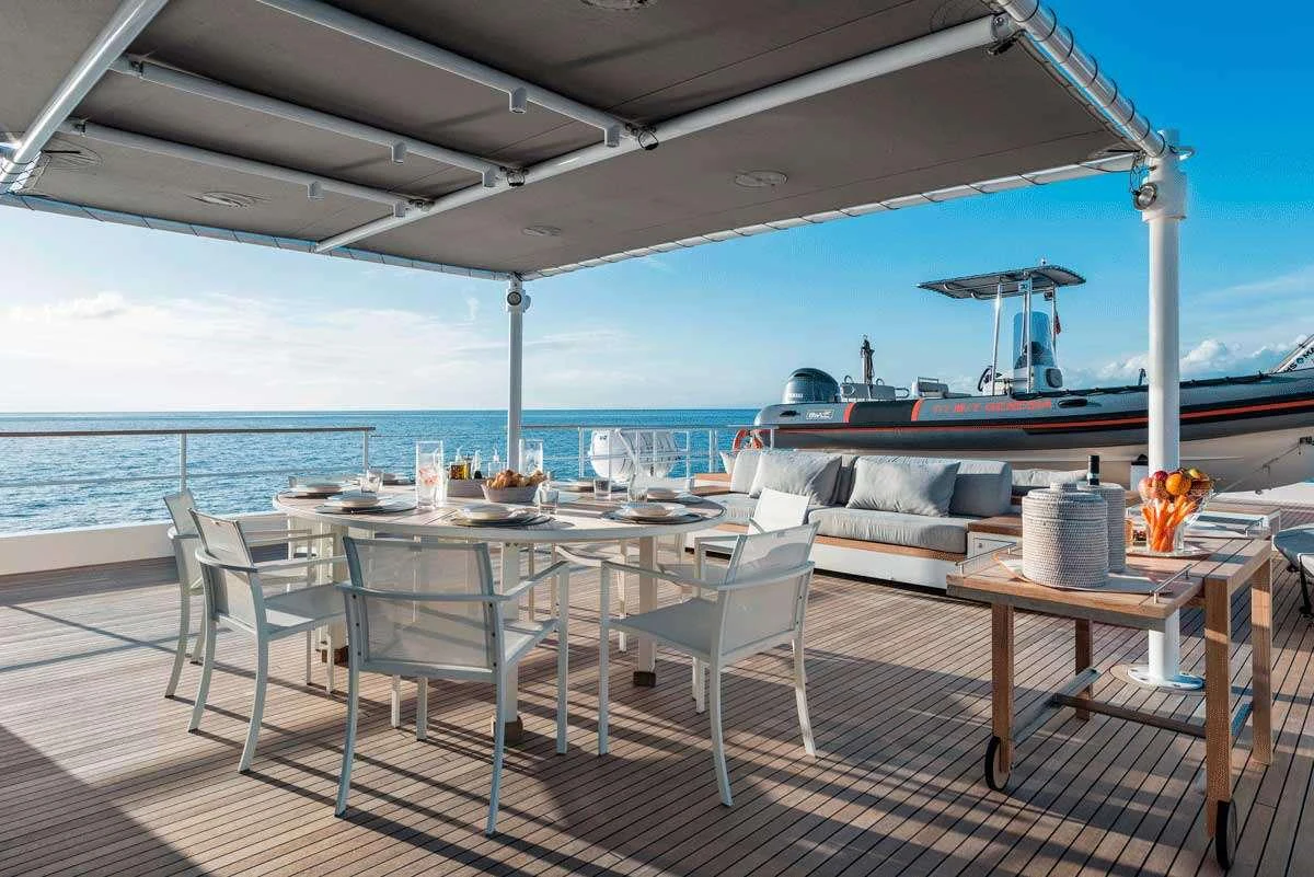 a table and chairs on a deck aboard GENESIA Yacht for Charter