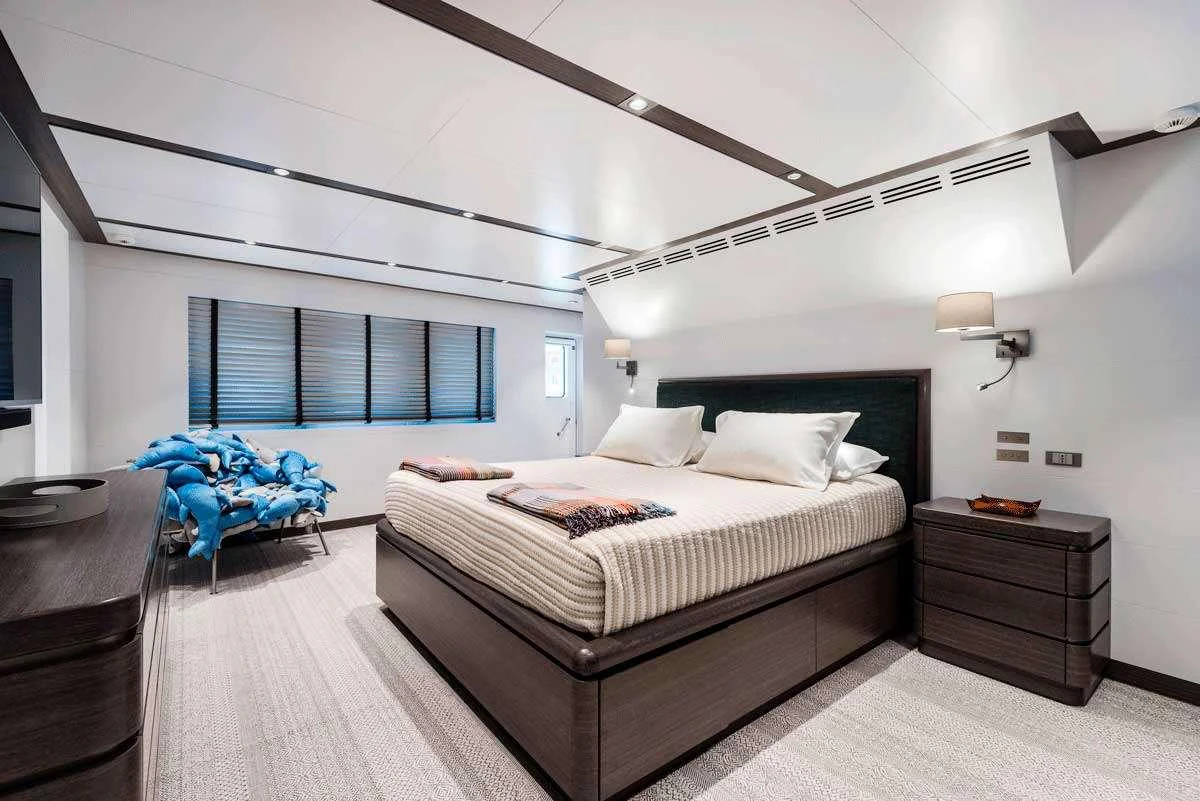 a room with a bed and a window aboard GENESIA Yacht for Charter