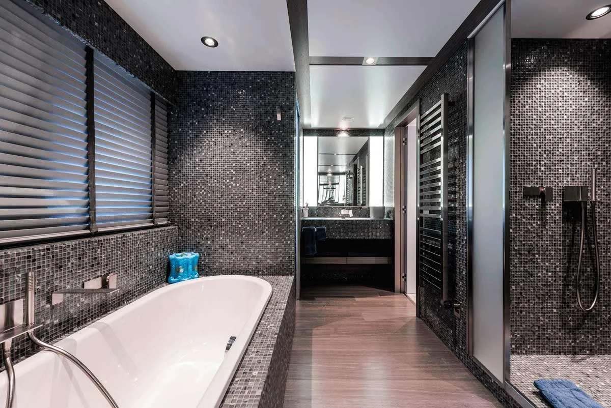 a bathroom with a tub and shower aboard GENESIA Yacht for Charter