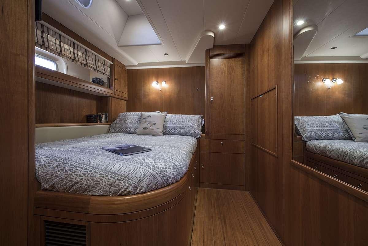 a bedroom with a bed and a wood door aboard MIDNIGHT Yacht for Charter