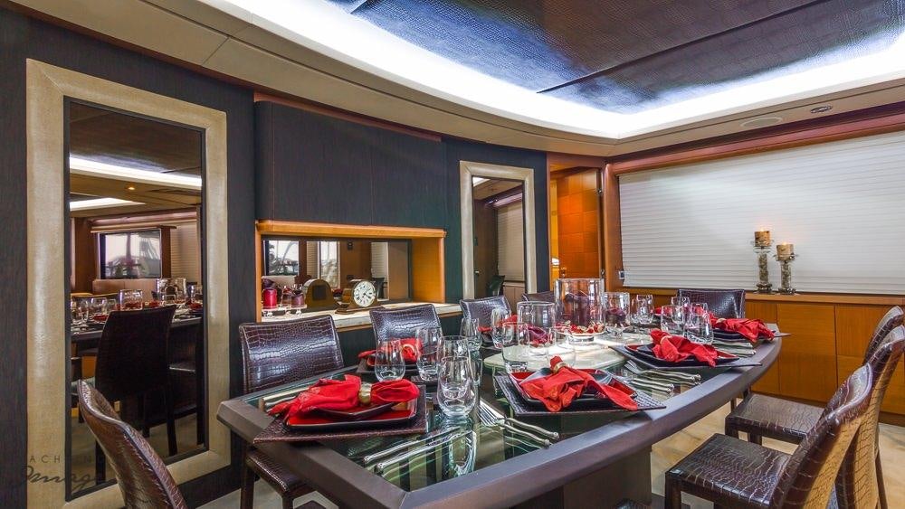 a dining room with a table and chairs aboard 105 YCG Yacht for Charter