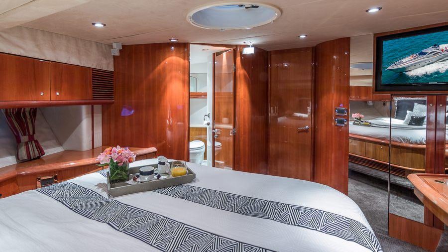 a bedroom with a bed and a television aboard H2 Yacht for Charter