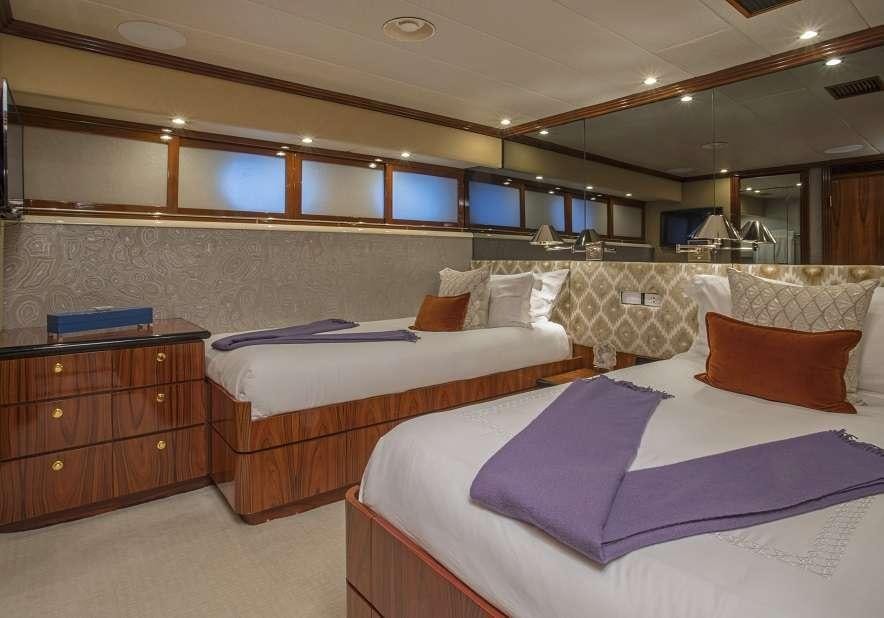 a room with beds and a large mirror aboard SWEET ESCAPE Yacht for Charter