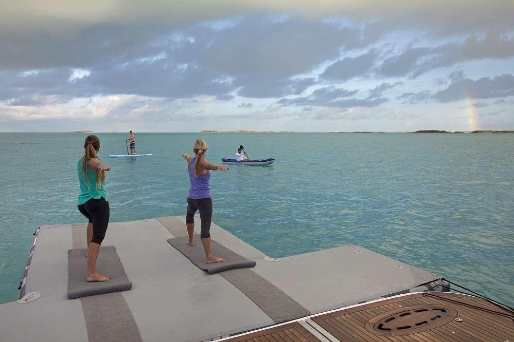a couple of women standing on a dock with a man and a woman on a boat in the aboard SWEET ESCAPE Yacht for Charter