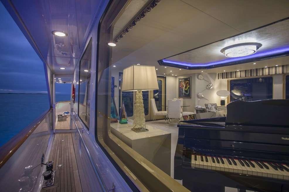 a large room with a wood floor and a large lamp on the side aboard SWEET ESCAPE Yacht for Charter