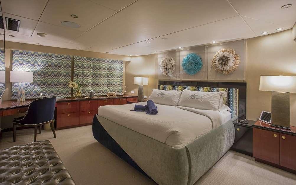 a bedroom with a bed and desk aboard SWEET ESCAPE Yacht for Charter