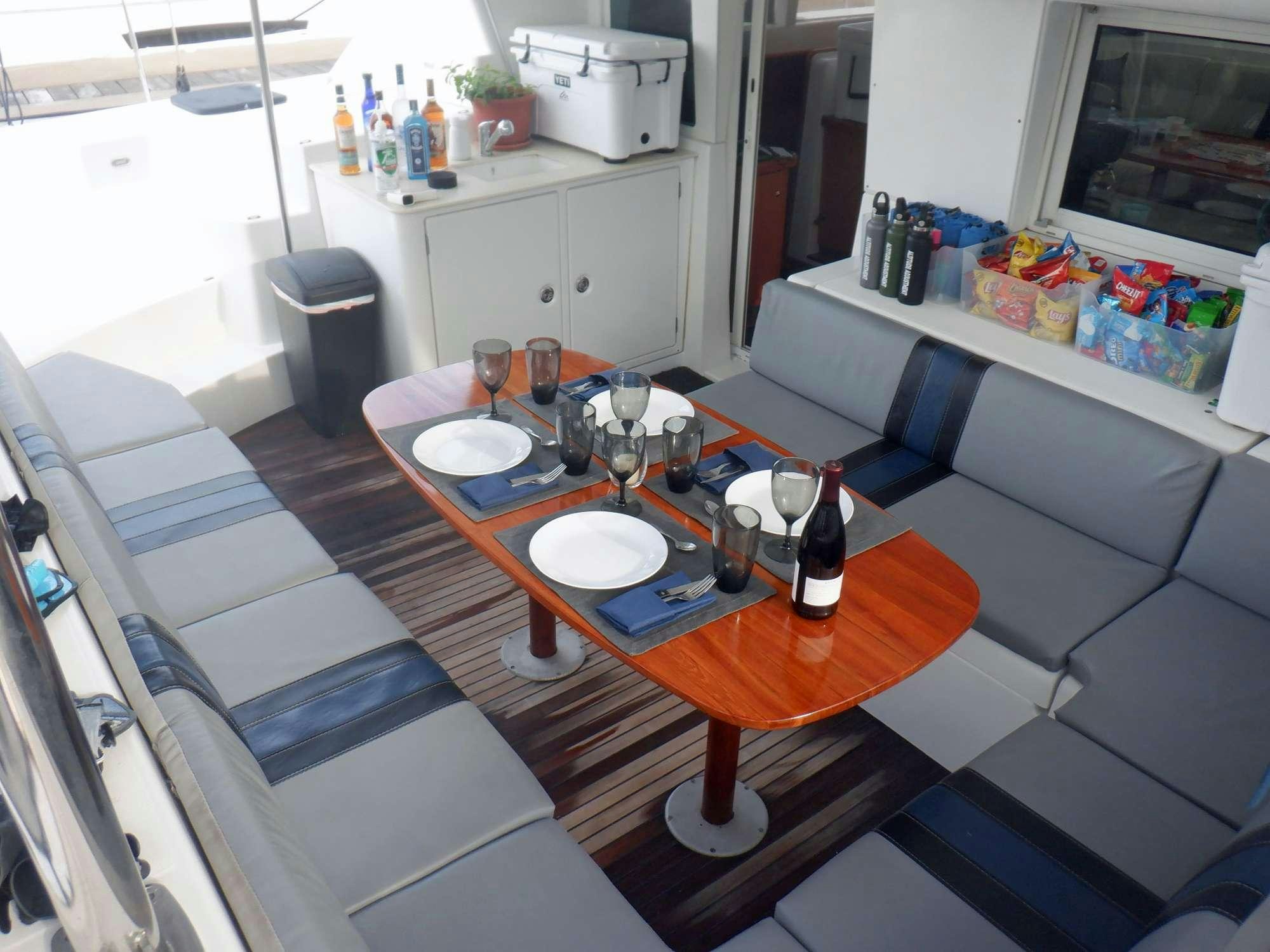 a table with plates and bottles on it aboard ALTITUDE ADJUSTMENT Yacht for Charter