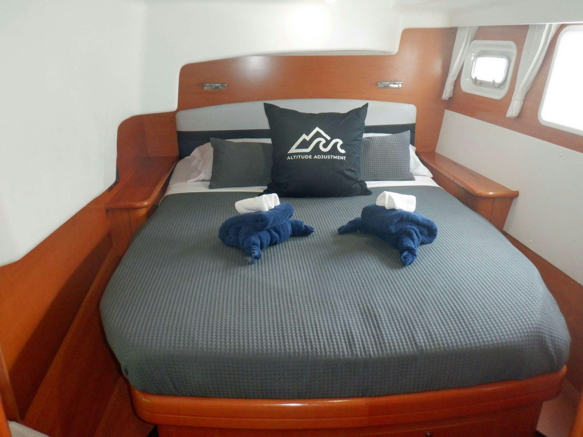 a bed with blue pillows aboard ALTITUDE ADJUSTMENT Yacht for Charter