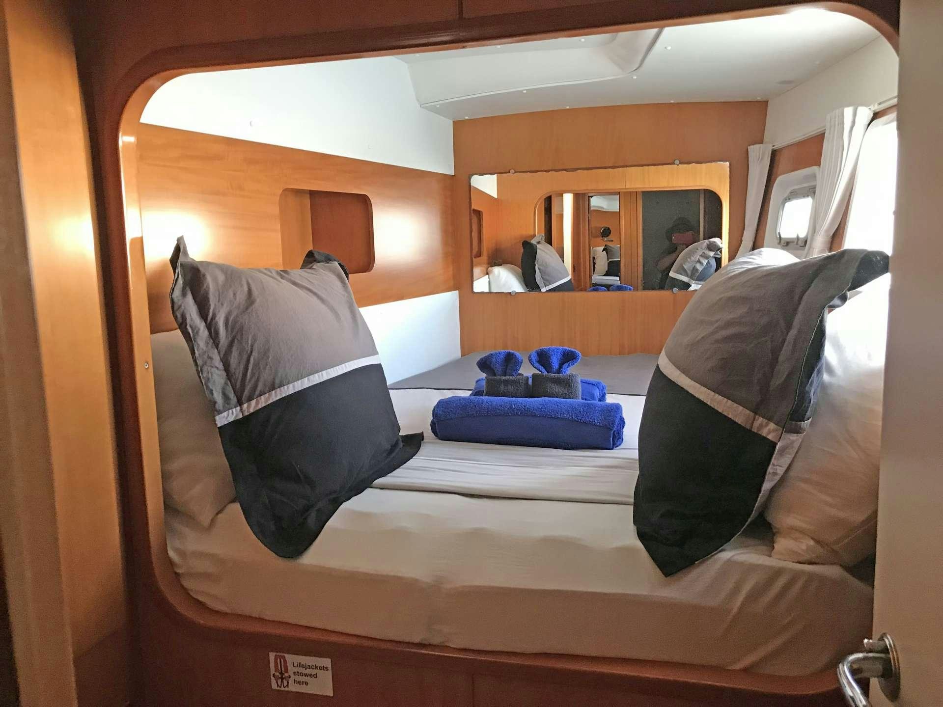 a room with a bed and a mirror aboard ALTITUDE ADJUSTMENT Yacht for Charter