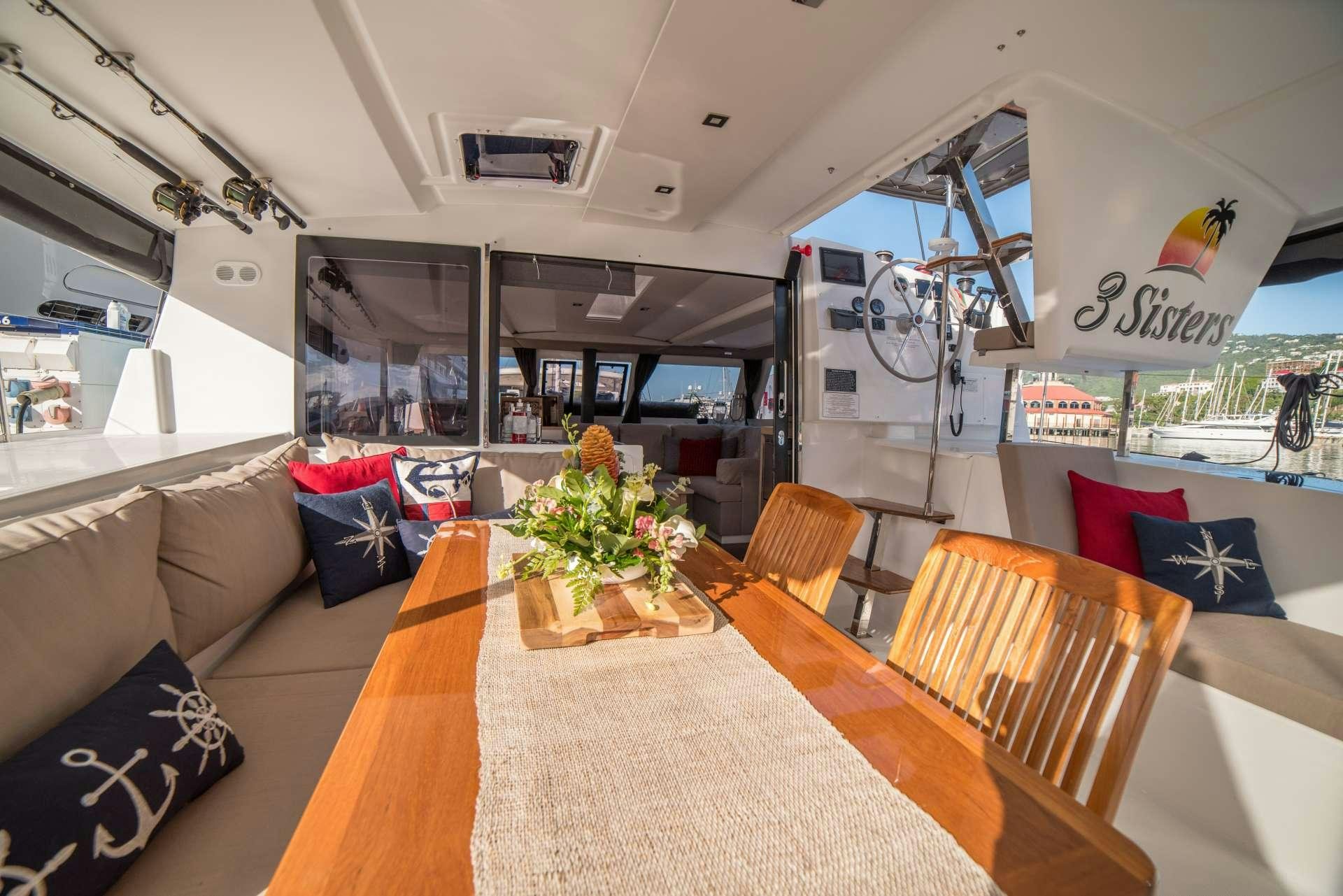 a living room with a large sofa and a table aboard 3 SISTERS Yacht for Charter