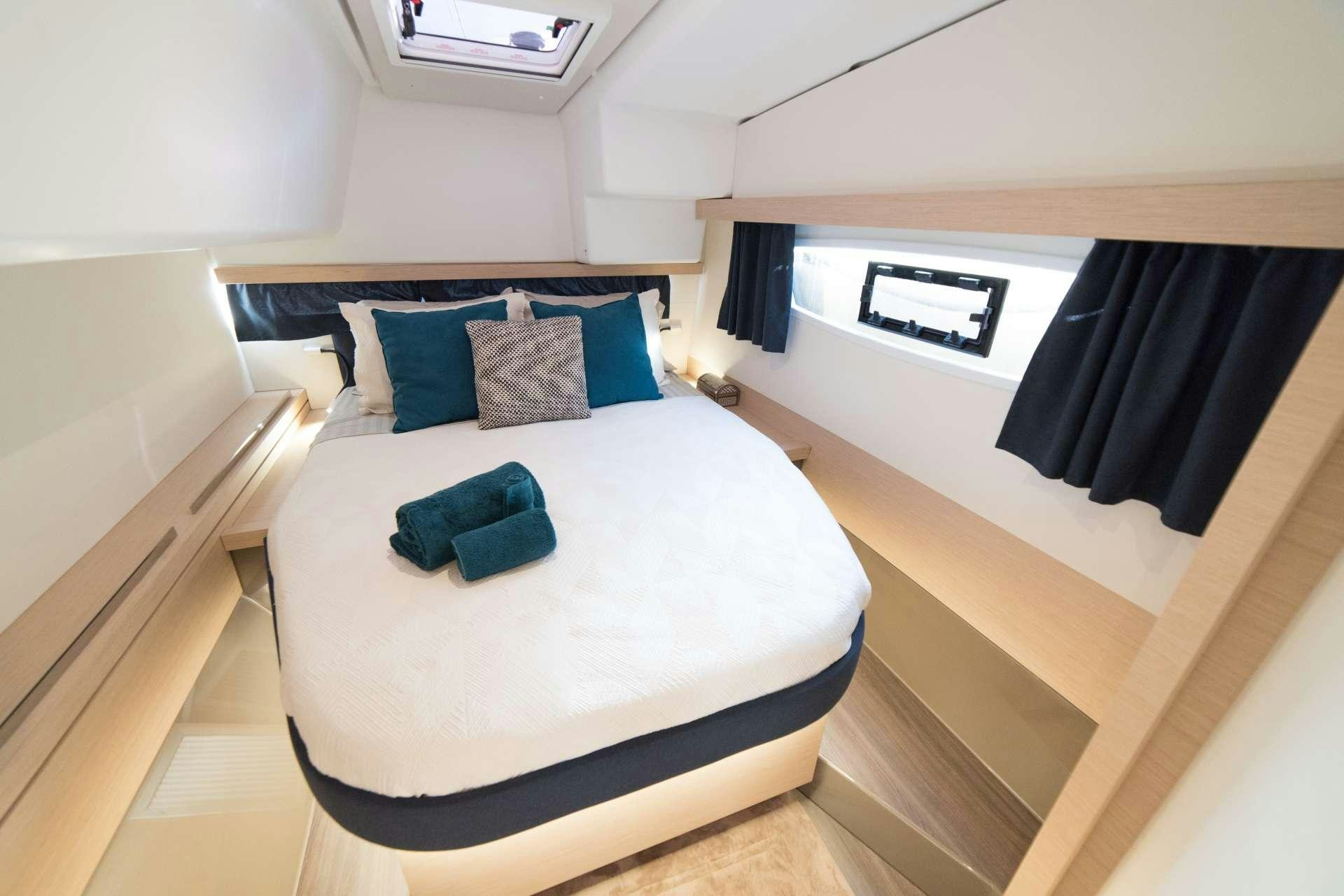 a bed with blue pillows aboard 3 SISTERS Yacht for Charter