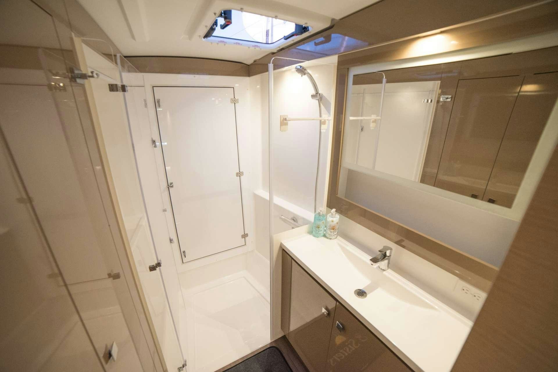 a bathroom with a sink and a shower aboard 3 SISTERS Yacht for Charter