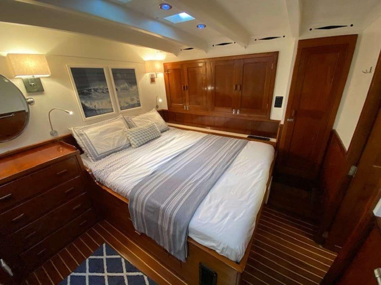 a bedroom with a bed and a desk aboard EROS Yacht for Charter