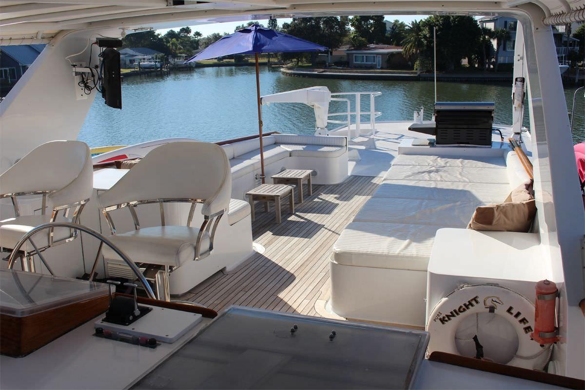 a lounge area with a pool and umbrellas aboard PURE KNIGHT LIFE Yacht for Charter