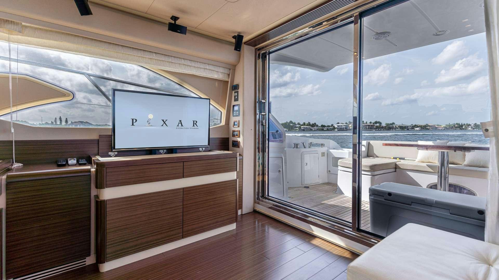 a room with a large window and a tv on the wall aboard ROLLIN DEEP Yacht for Charter