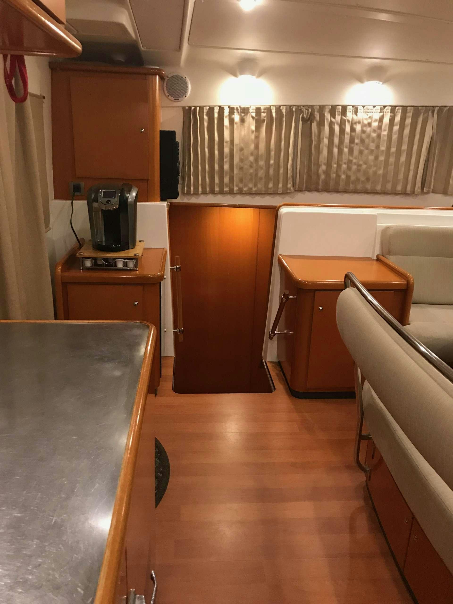 a kitchen with a table and a refrigerator aboard BLACK SHEEP Yacht for Charter
