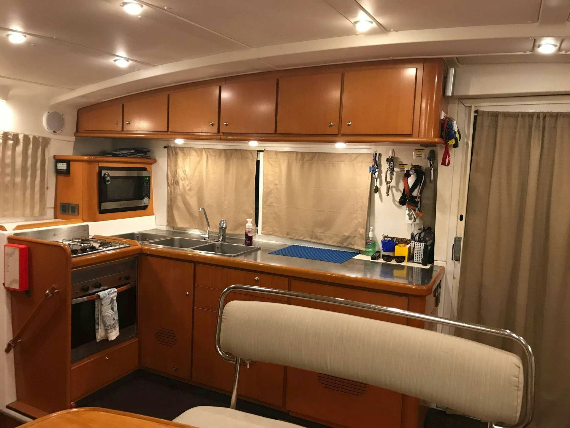 a kitchen with wooden cabinets aboard BLACK SHEEP Yacht for Charter