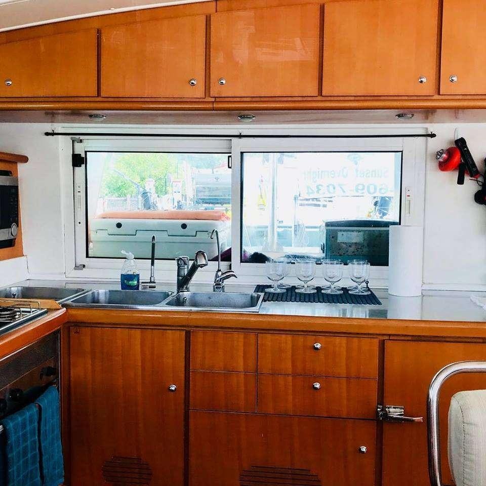 a kitchen with wooden cabinets aboard BLACK SHEEP Yacht for Charter