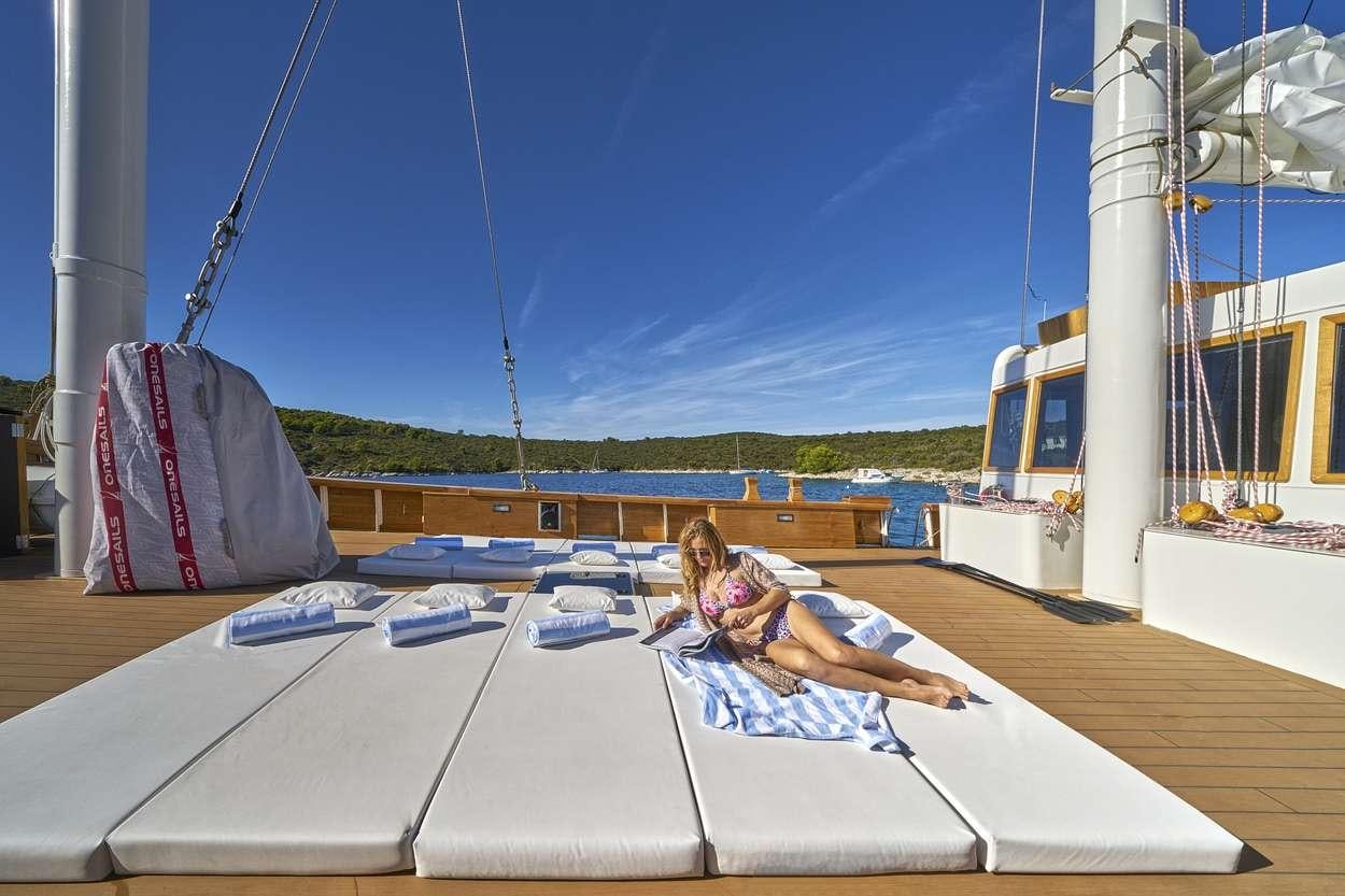a couple of girls sitting on a boat on the water aboard ARDURA Yacht for Charter
