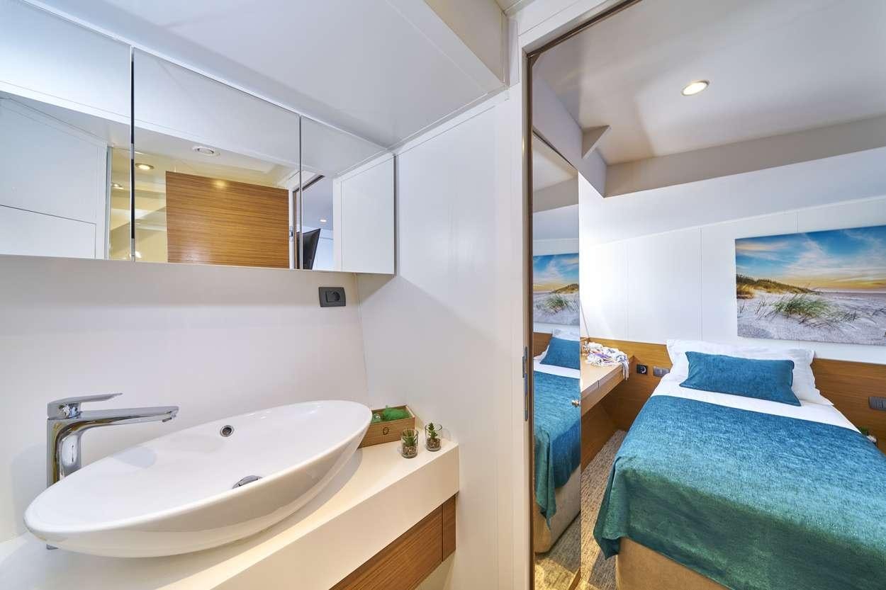 a bathroom with a sink and a bed aboard ARDURA Yacht for Charter