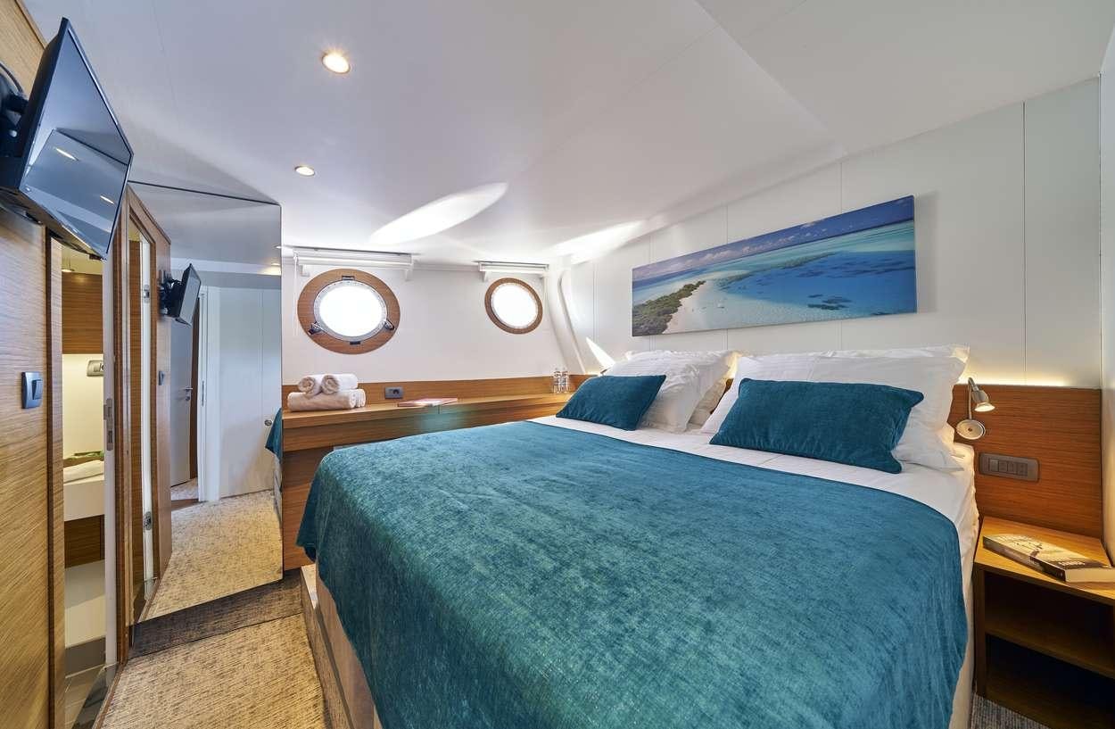 a bedroom with a bed and a desk aboard ARDURA Yacht for Charter