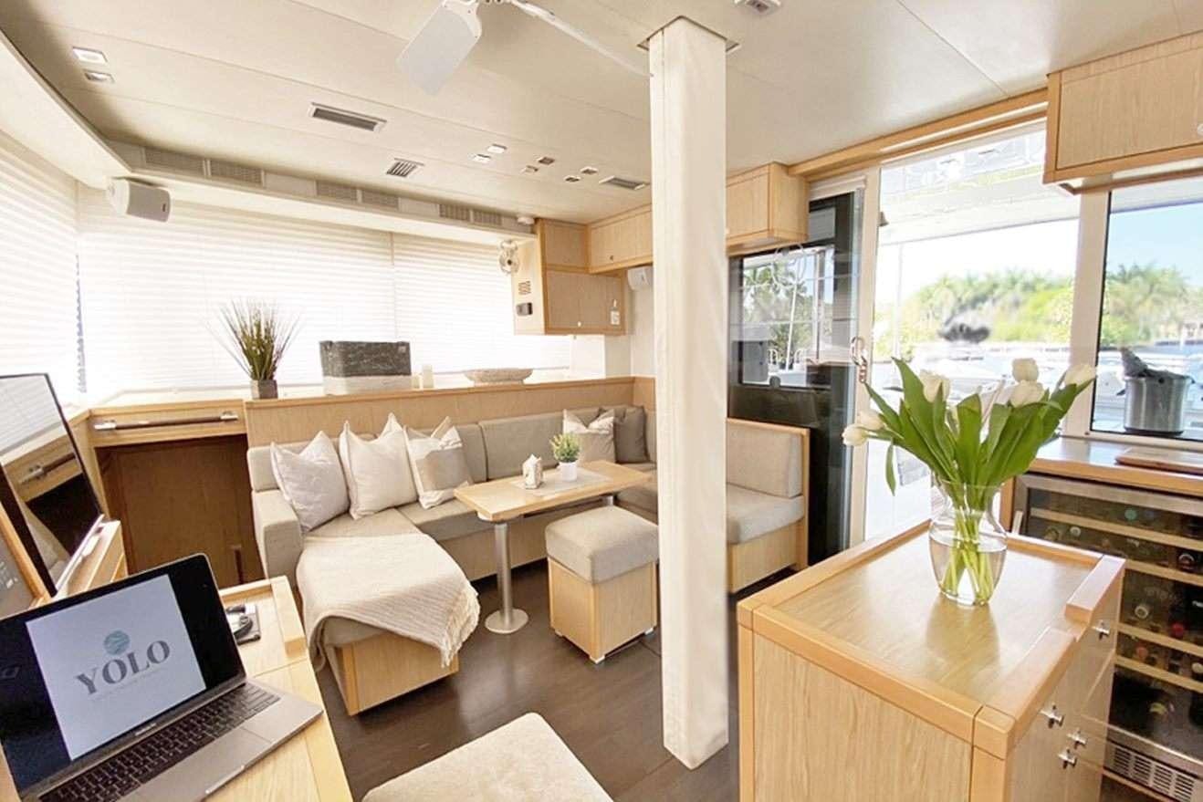 a living room with a laptop and a table aboard YOLO II Yacht for Charter