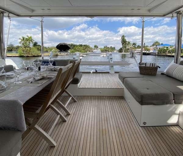a deck with chairs and tables aboard YOLO II Yacht for Charter