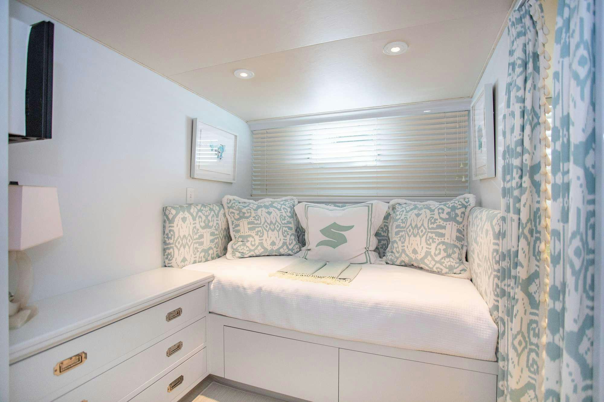 a white couch with a blue and white striped pillow on it aboard SOVEREIGN Yacht for Charter