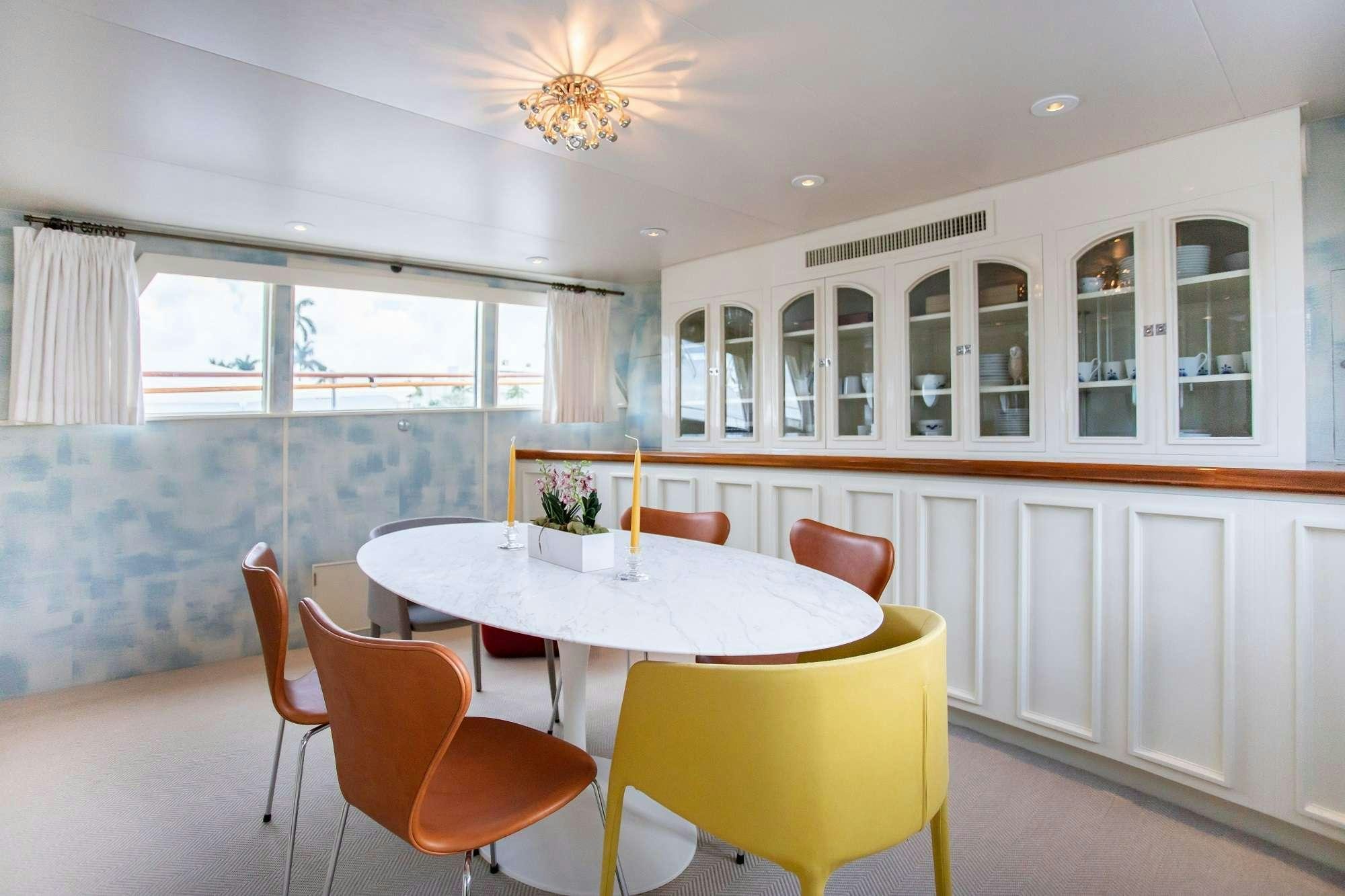 a dining room with a table and chairs aboard SOVEREIGN Yacht for Charter