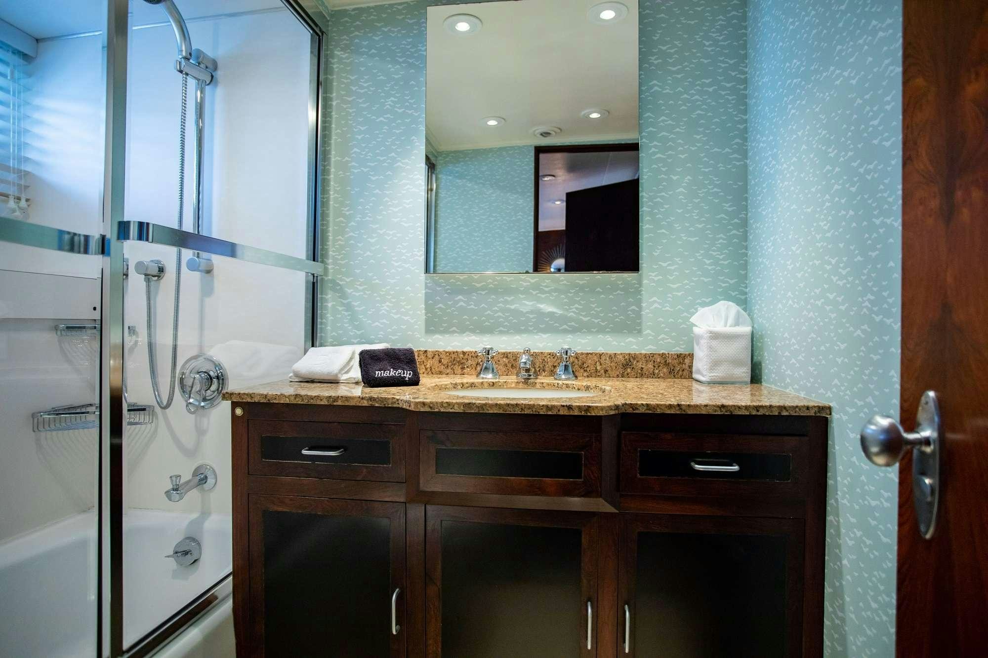 a bathroom with a sink and a shower unit aboard SOVEREIGN Yacht for Charter