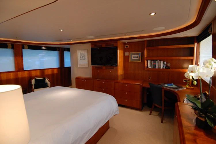 a bedroom with a bed and desk aboard DONA LOLA Yacht for Charter