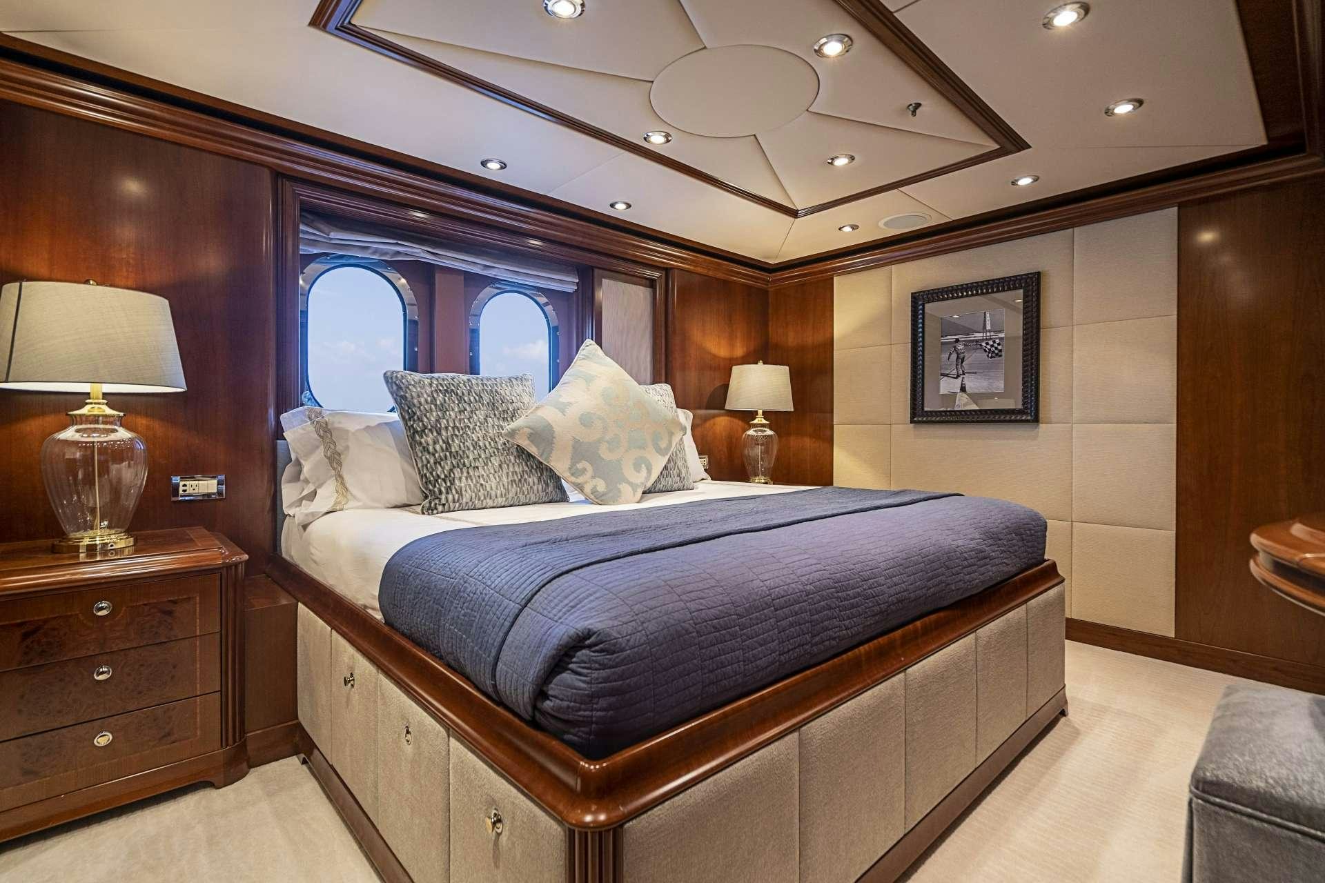 a bed with a blue comforter aboard CAMILLE Yacht for Charter