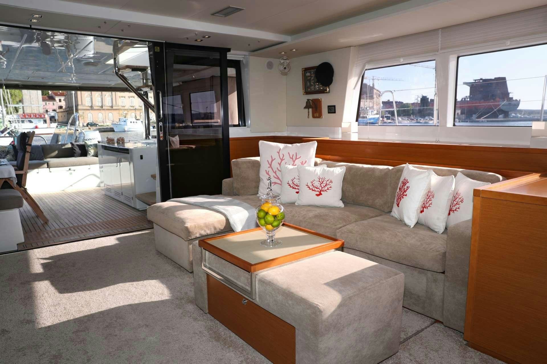 a living room with a couch and coffee table aboard Spirit of Adventure Lagoon 620  Yacht for Charter