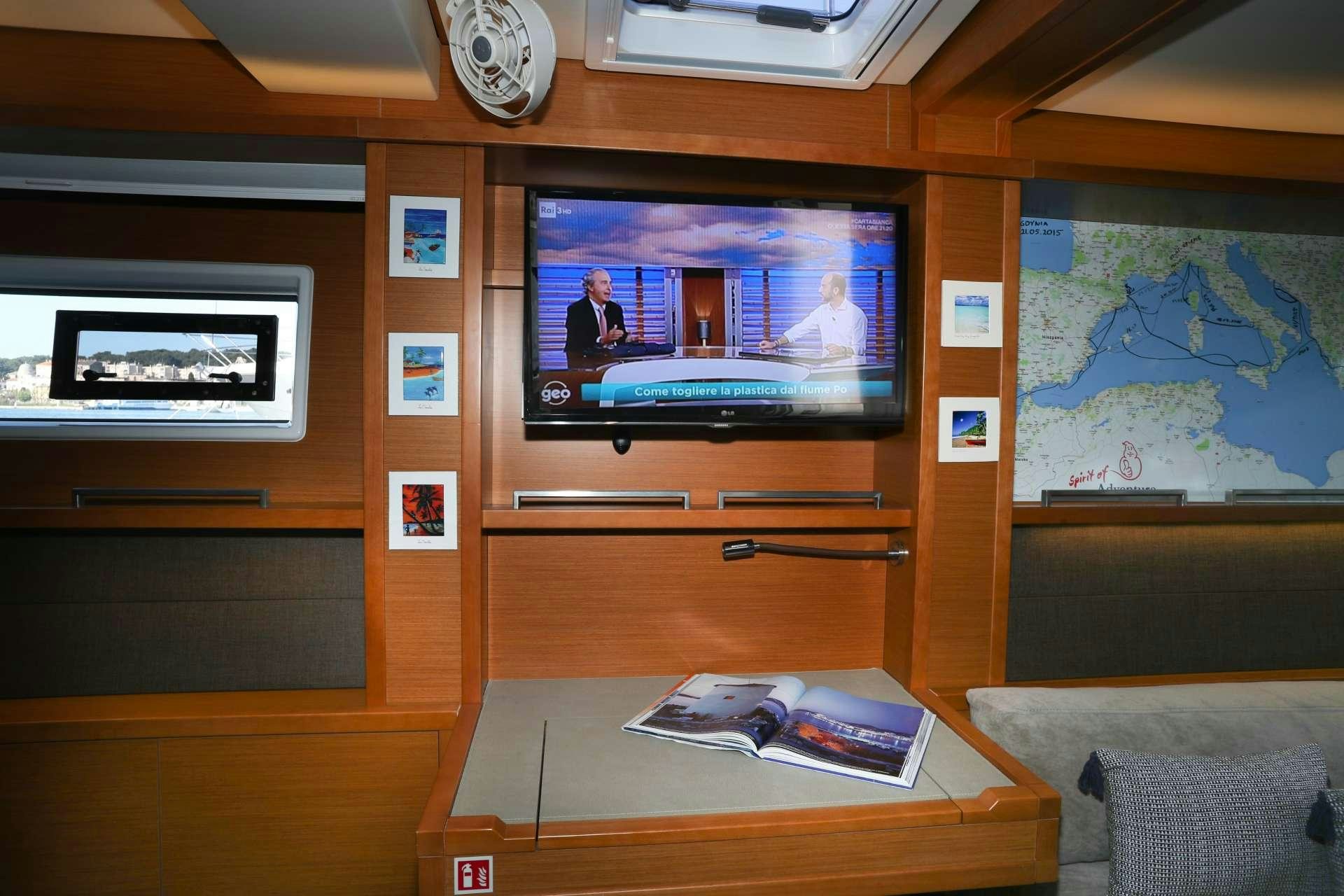 a room with a tv and a table aboard Spirit of Adventure Lagoon 620  Yacht for Charter