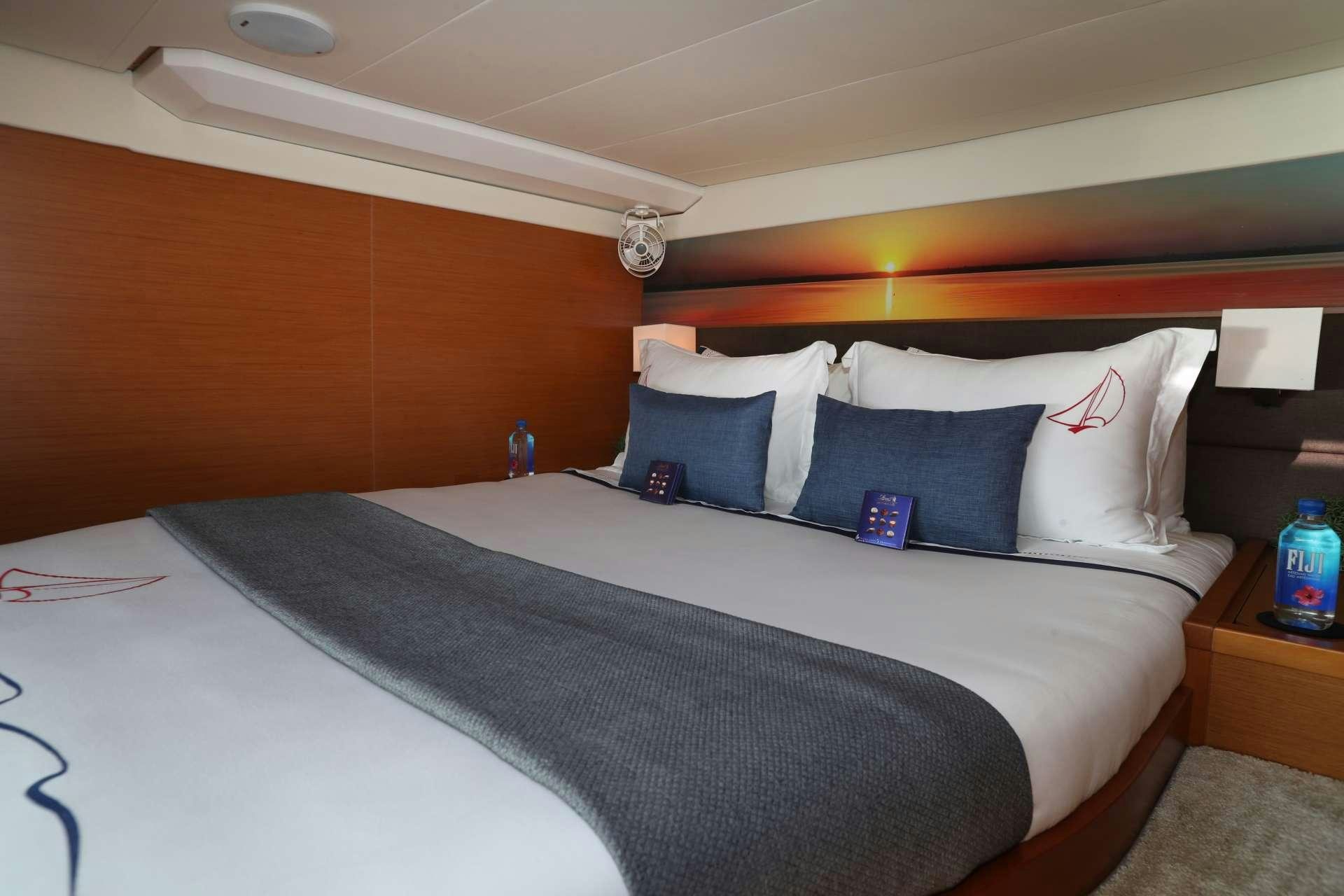 a bed with white sheets and pillows aboard Spirit of Adventure Lagoon 620  Yacht for Charter