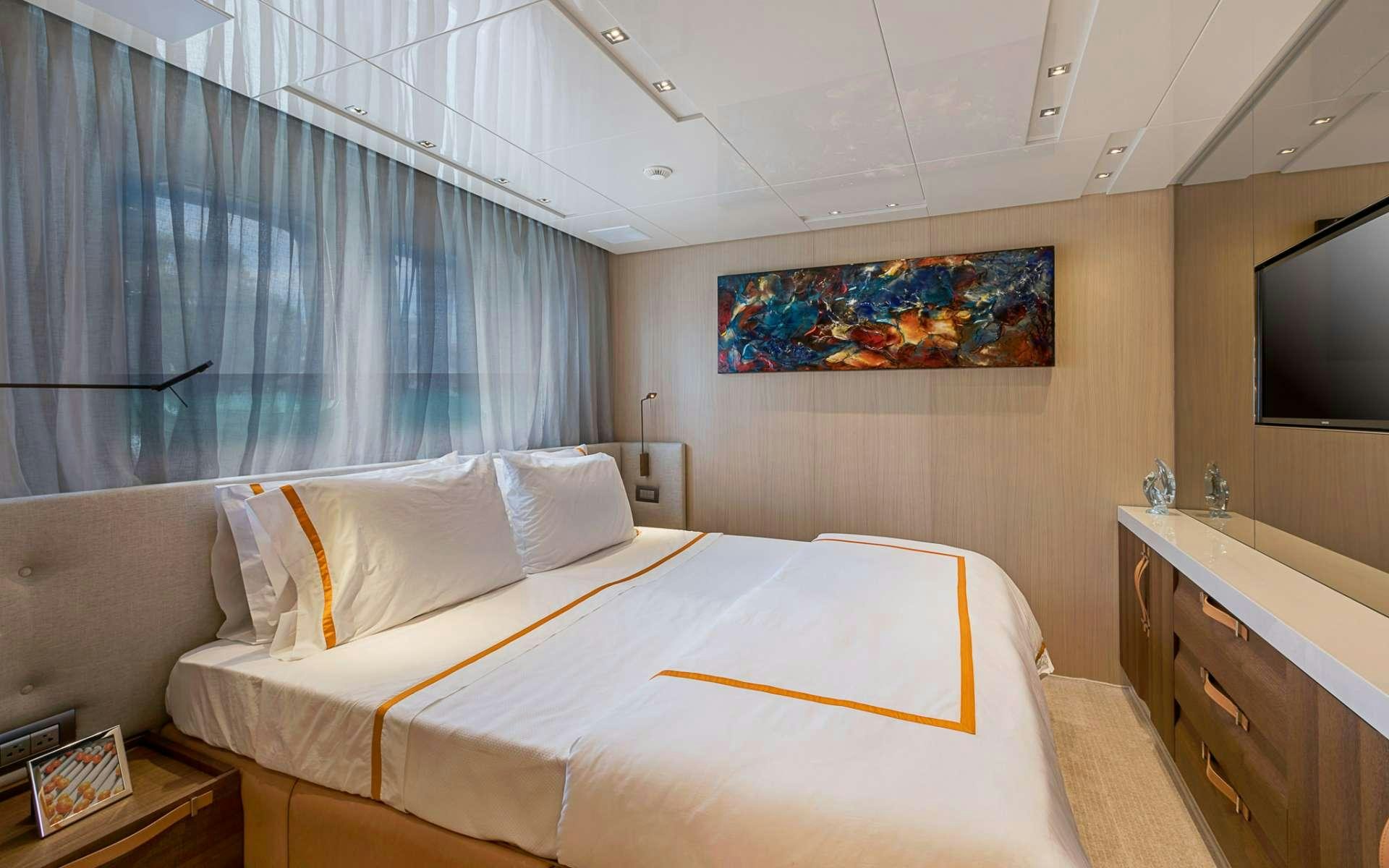 a bedroom with a bed and a tv aboard NOTORIOUS Yacht for Charter